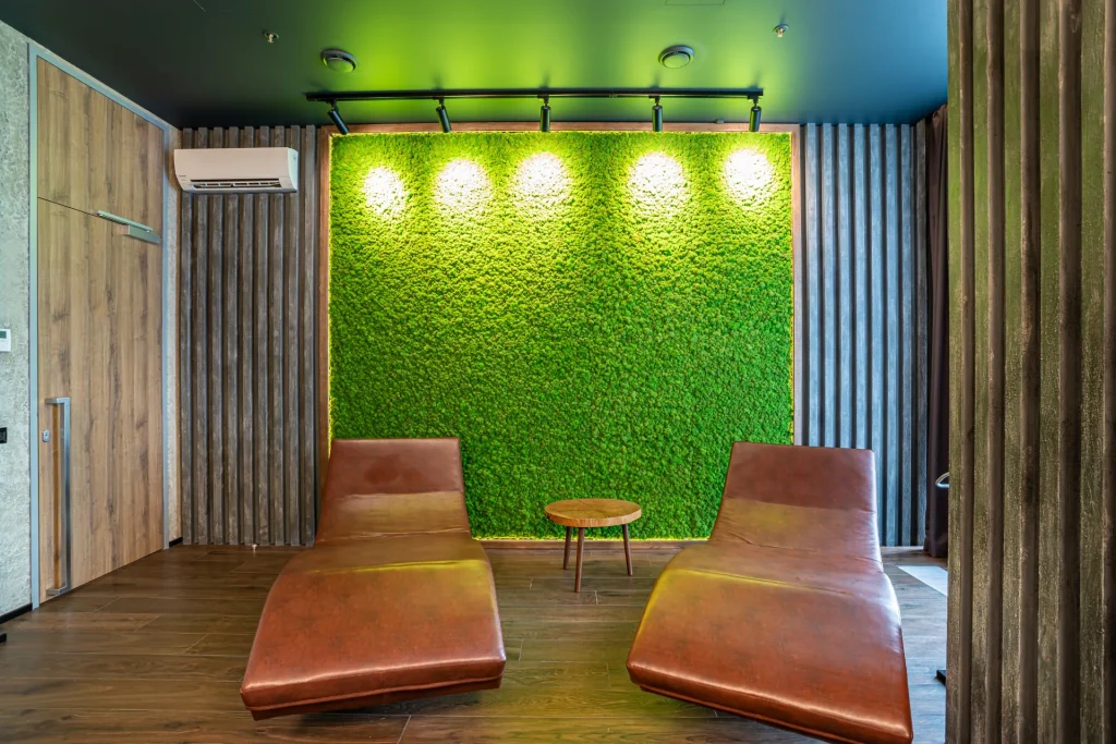 Relaxation area at Anvil Fitness Club with two leather loungers and a decorative green moss wall