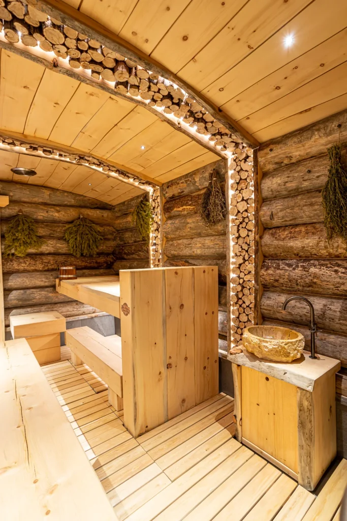 Interior of the Russian banya at Anvil Fitness Club with wooden benches, log walls and decorative timber beams