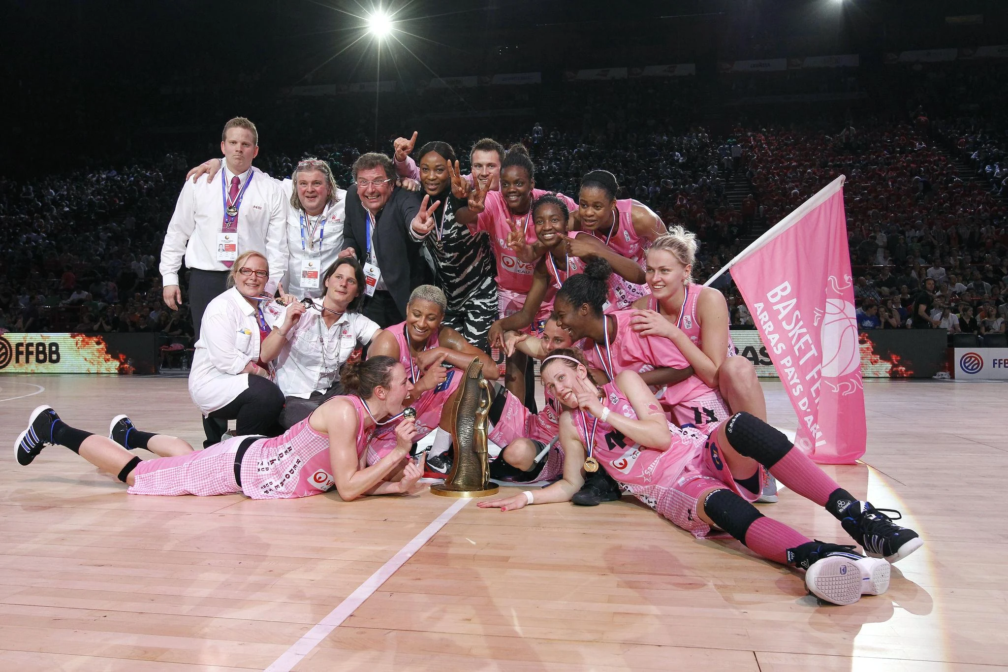 Arras Pays d'Artois basketball players in pink jerseys lifting the French Cup trophy after their historic 2012 victory.