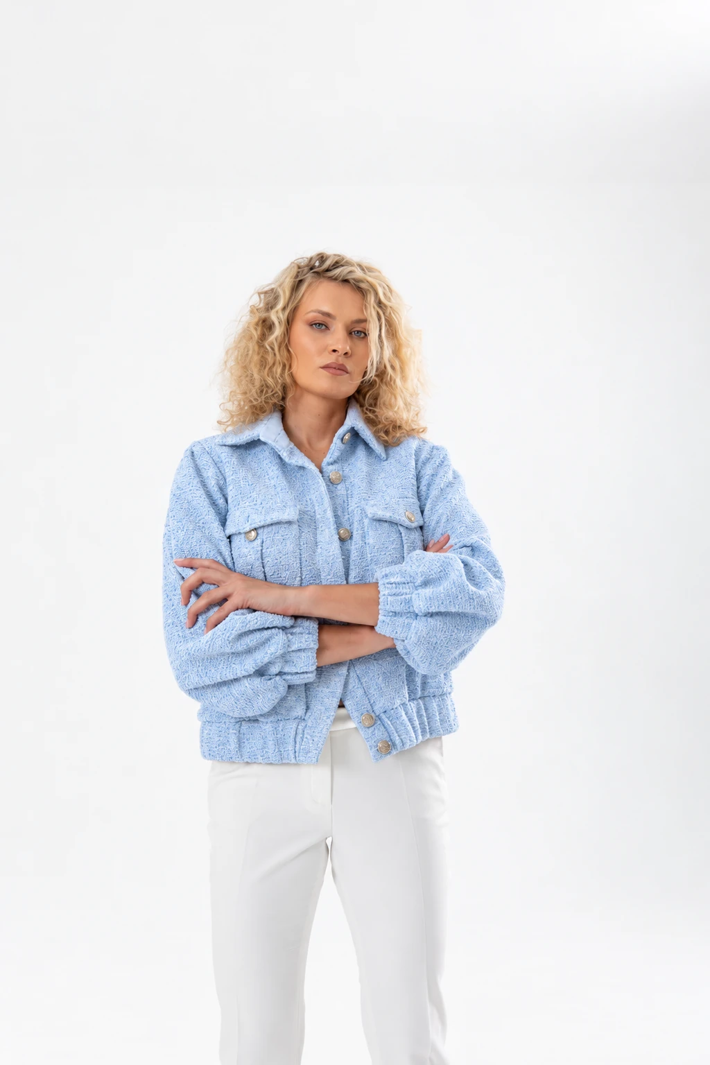 Nadezhda Grishaeva in a light blue jacket and white trousers in a studio portrait
