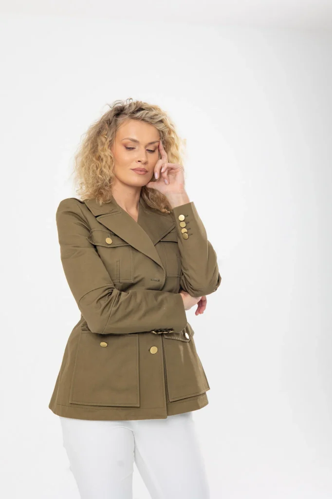 Nadezhda Grishaeva in an olive jacket and white trousers in a studio portrait