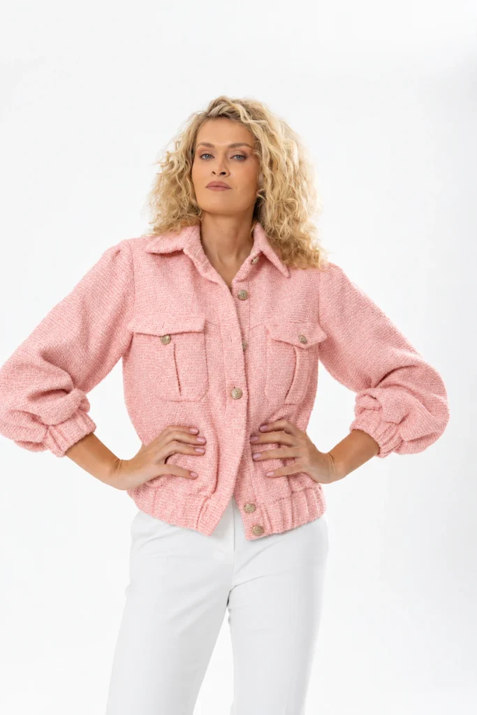 Nadezhda Grishaeva in a pink textured jacket and white trousers in a studio portrait