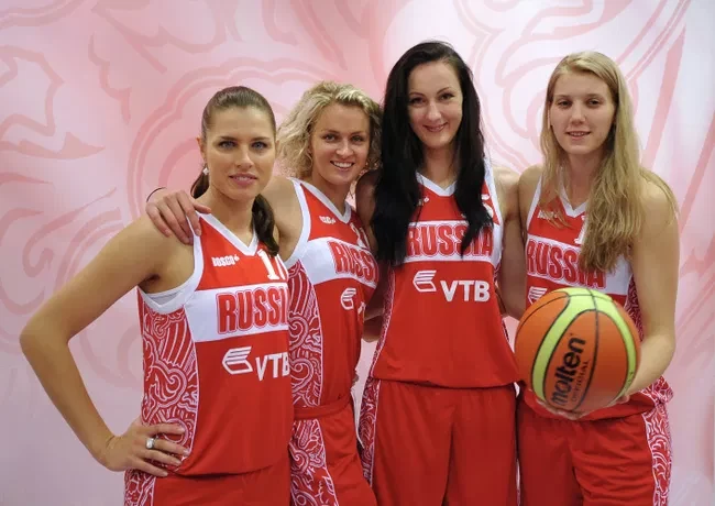 Nadezhda Grishaeva posing with fellow Russian national women's basketball team players in red Russia uniforms.