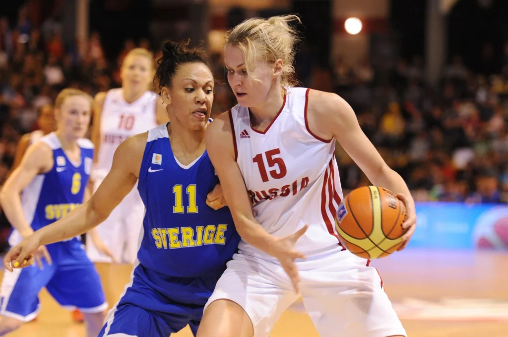 Nadezhda Grishaeva wearing jersey number 15 for Russia, protecting the basketball against Sweden during an international women's basketball game.