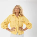 Nadezhda Grishaeva in a yellow textured jacket and white trousers in a studio portrait